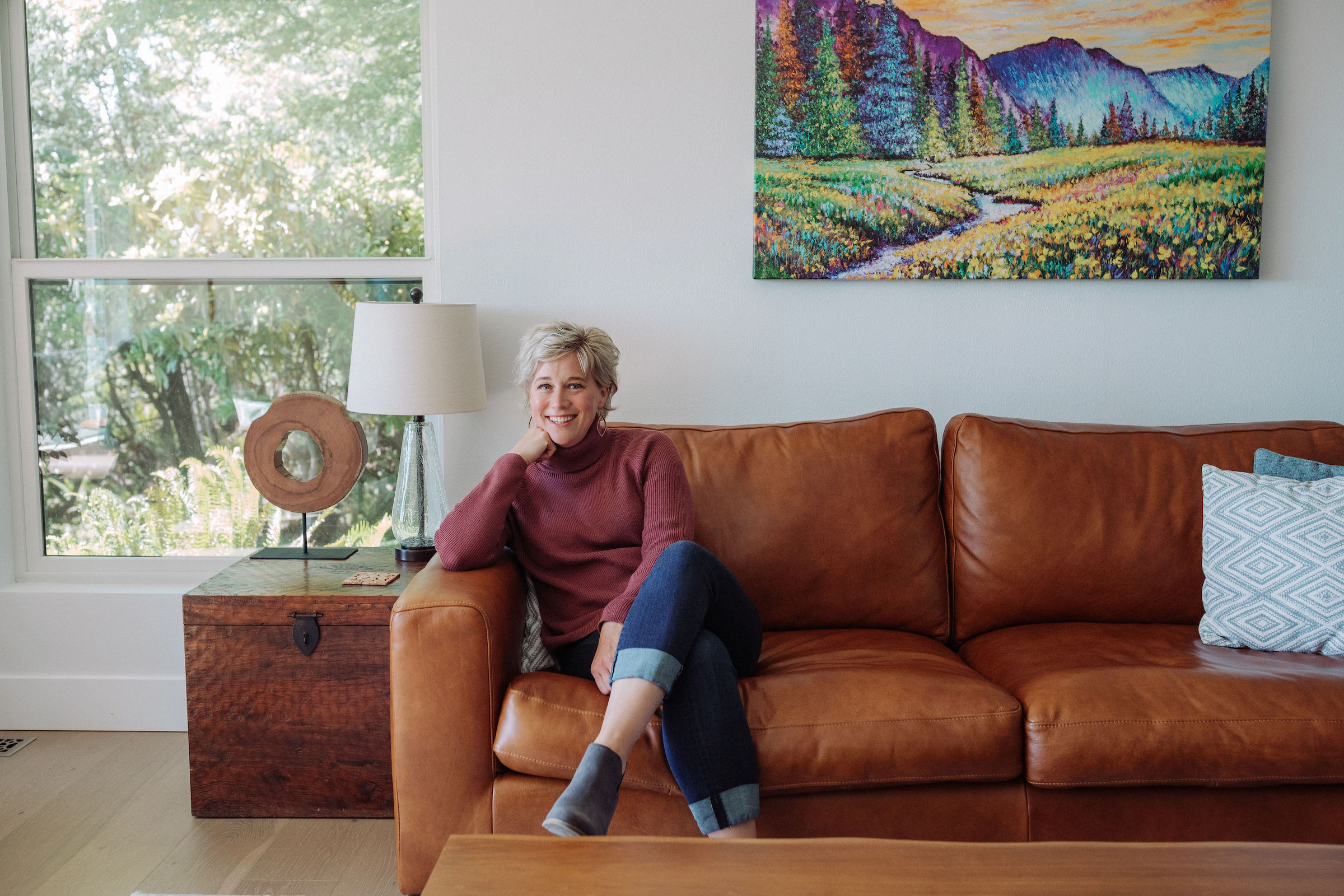 motivational business speaker Megan Gluth-Bohan sits on a leather couch